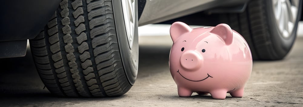 tirelire cochon à côté d'un pneu de voiture